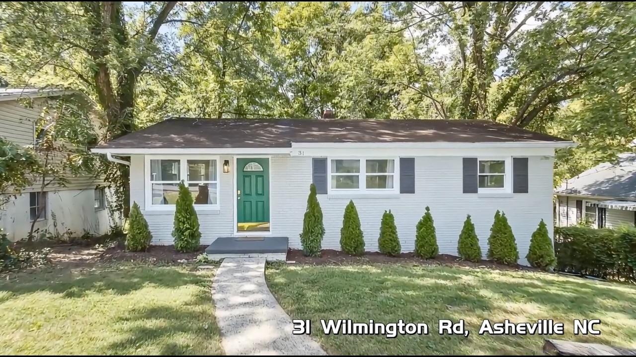 White brick ranch, green door, new shrubs. Still from the listing walk. The burned-in address is part of this image.
