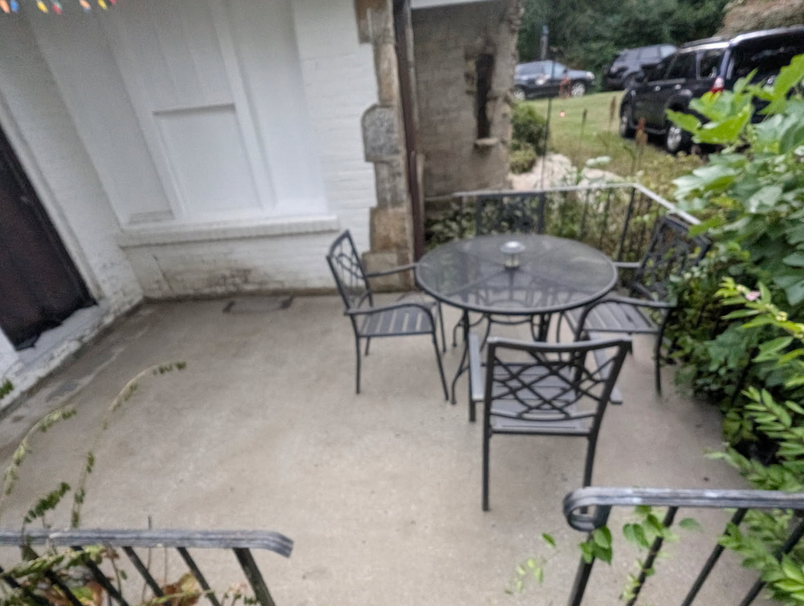 Same patio from a second angle, glass table and metal chairs.
